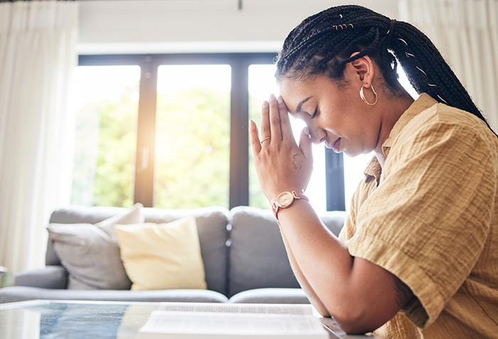 Woman praying in her family room